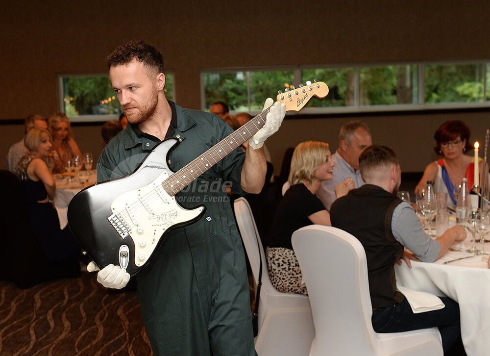 Man showing a guitar at a Antiques Auction Corporate Event