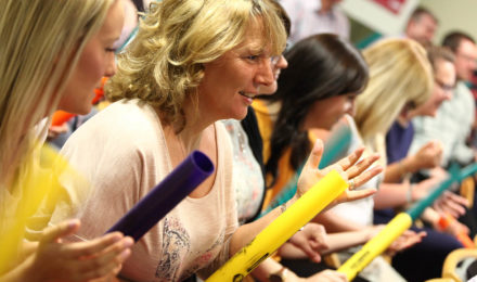 Women using boomwhackers at a conference ice breaker