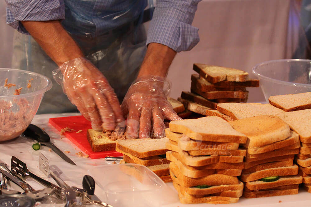 Man making sandwiches to raise money at charity team apprentice team building event