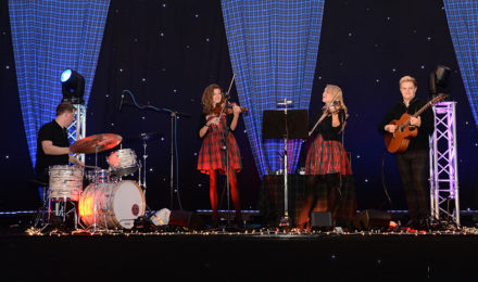 Scottish girls in a band playing at a Scottish themed company party