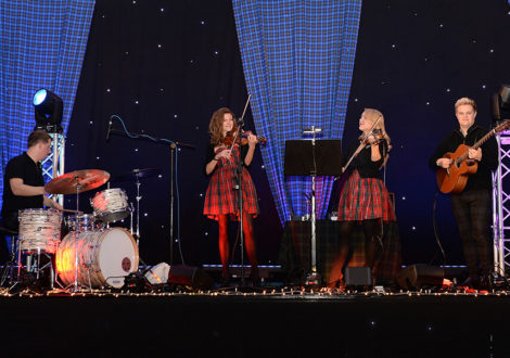 Scottish girls in a band playing at a Scottish themed company party