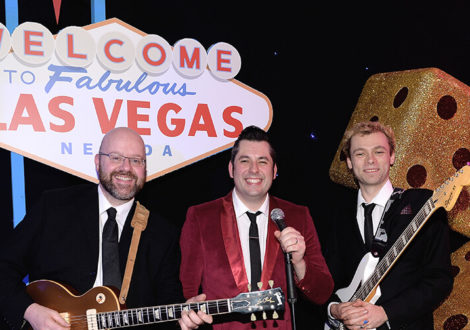 Rock n Roll band in front of a Las Vegas sign at a corporate event