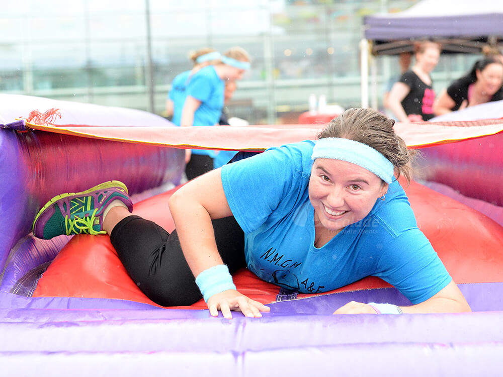 Lady on inflatable It's a Knockout team building event