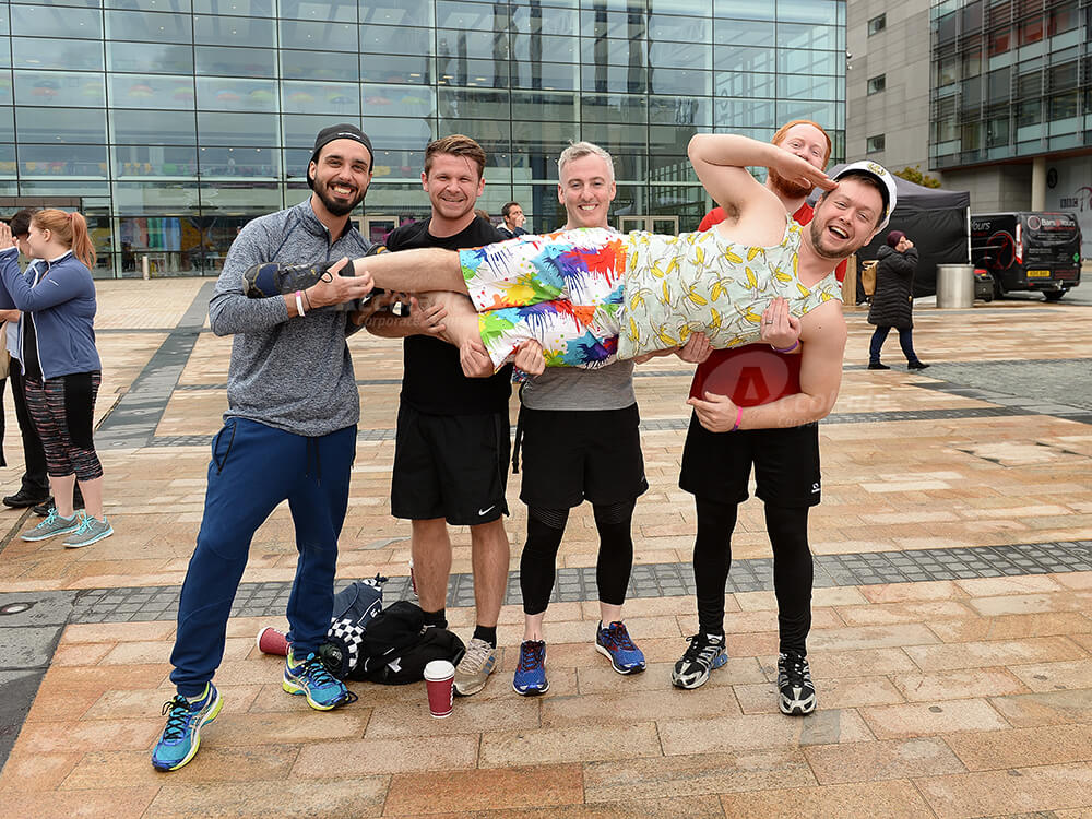 Man being carried by team at It's a Knockout team building event