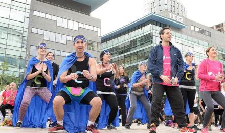 Team in capes warming up by BBC building for It's a Knockout team build