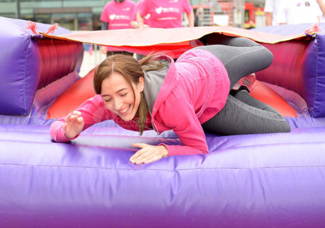 Lady laughing on inflatable for It's a Knockout team building event