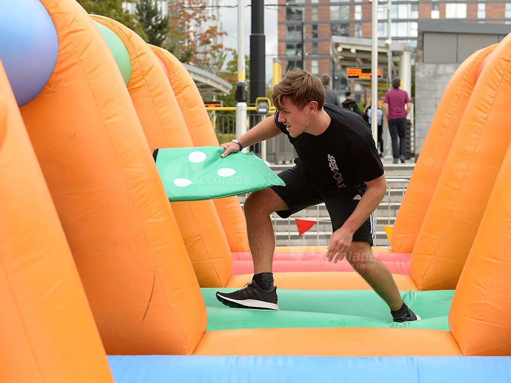 Man running on inflatable for It's a Knockout team building corporate event