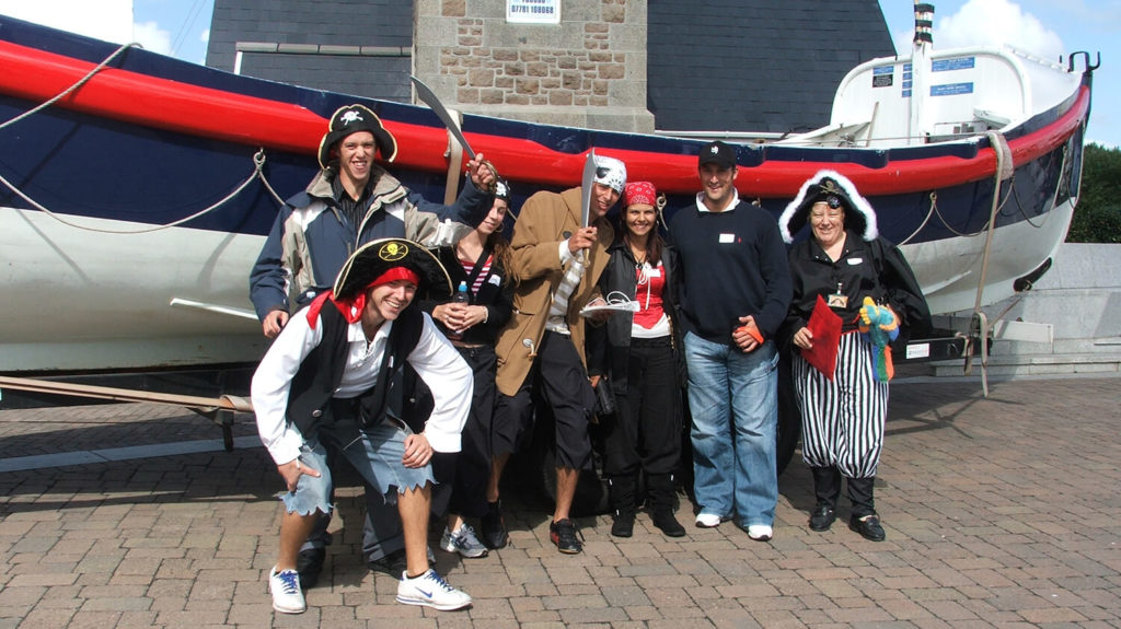 Pirate team posing by lifeboat in Spy Catcher corporate event