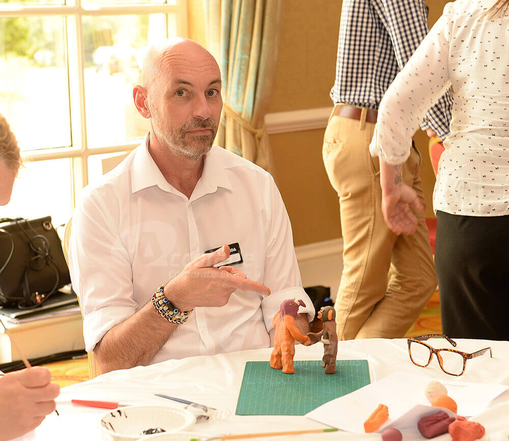 Man pointing to Plasticine models at Team Animation team event