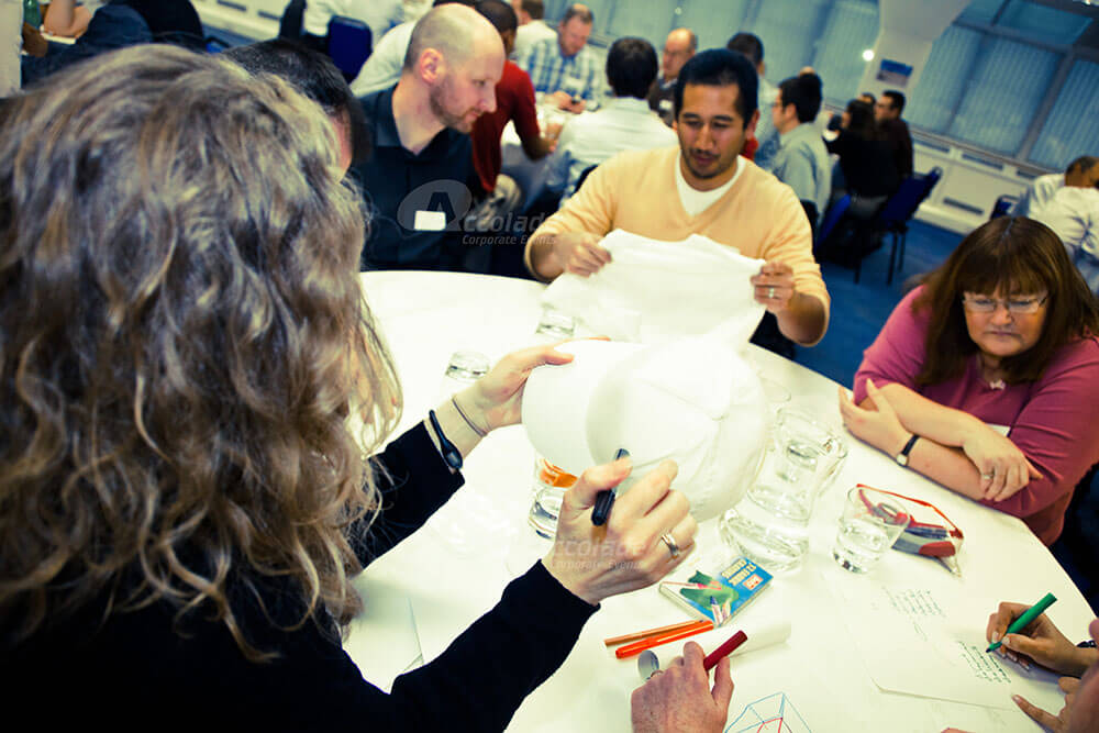 Team sitting around a table in Team Apprentice team building event