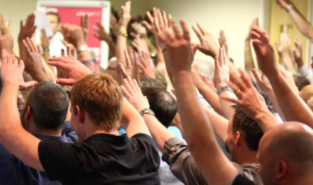 Conference ice breaker with people with hands in the air