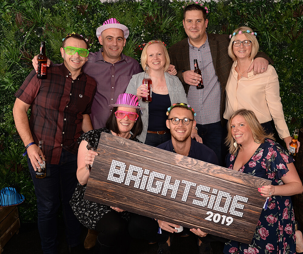 People posing in photo area at indoor corporate festival event