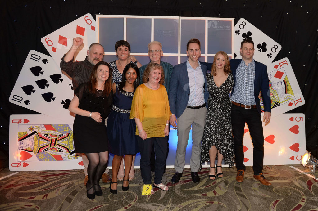 Team in front of giant card wall at Play your cards